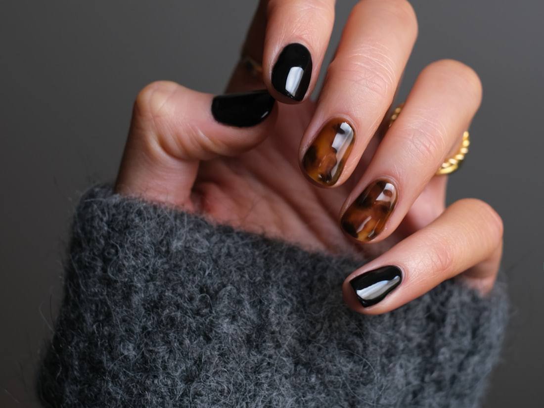 Unhas em gel com acabamento escuro e detalhe dourado